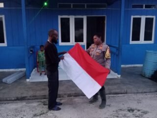 Kasat Binmas Polres Mamberamo Tengah Serahkan Bendera Merah Putih kepada Kepala Kampung Moga Jelang HUT ke-81 Kemerdekaan RI